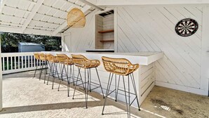 Un espace extérieur abrité, doté d’un bar et de sièges.