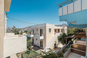 A multi-story building with a balcony, a staircase, and a view of the surrounding area.
