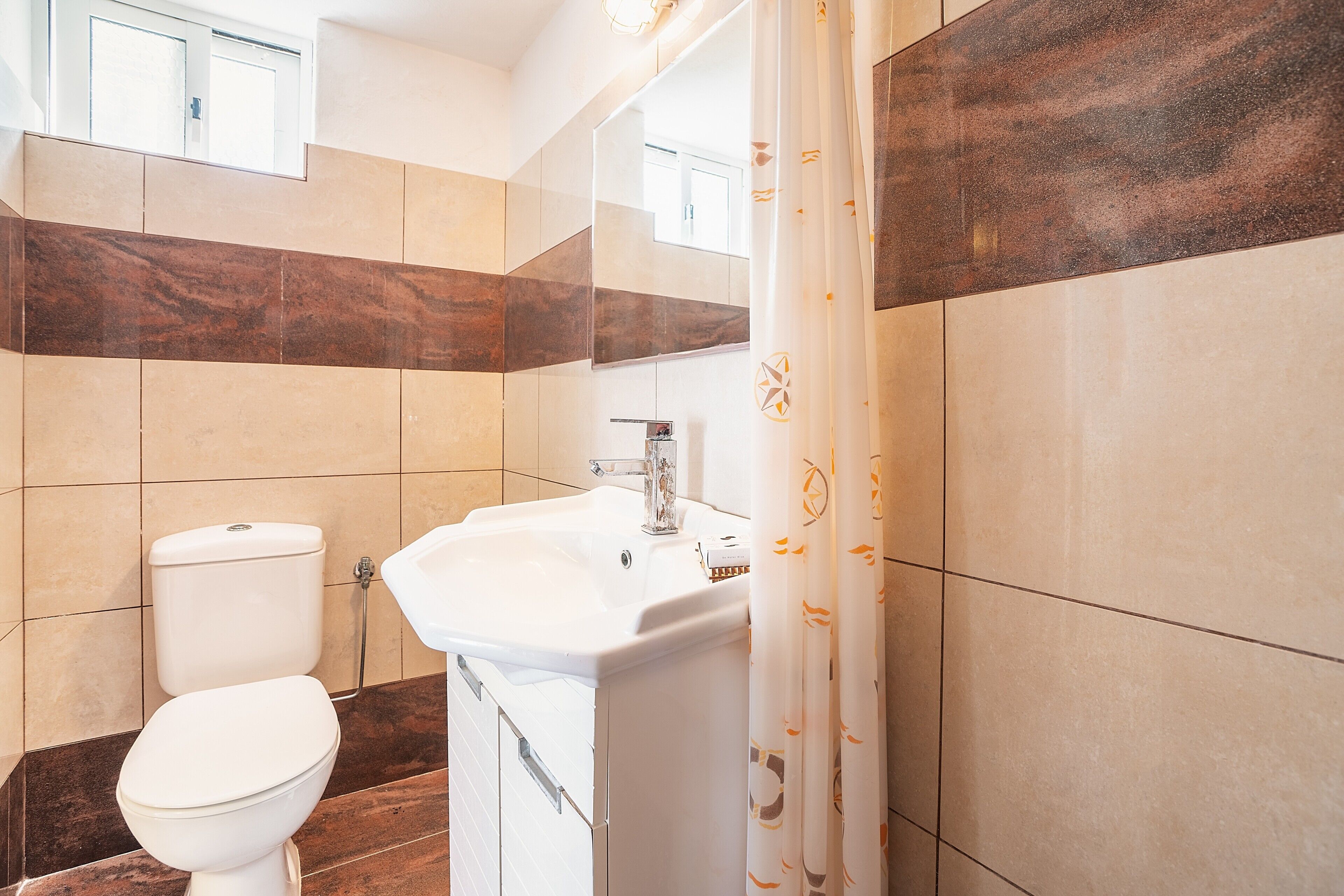 Une salle de bain avec des toilettes, un lavabo et un rideau de douche.