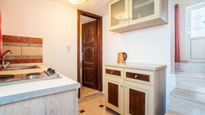 Una cocina con estufa, lavaplatos y armarios.