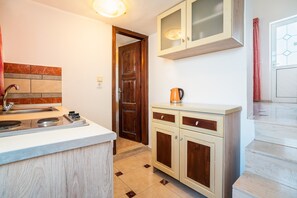 A kitchen with a stove, sink, and cabinets.