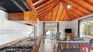 A kitchen with a gas stove, wooden cabinets, and a tiled backsplash.