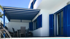 A pool area with a covered seating area, a chair, and a table. - Holiday Home 'Villa Katarina' with Private Pool, Wi-Fi and Air Conditioning (Lanzarote)