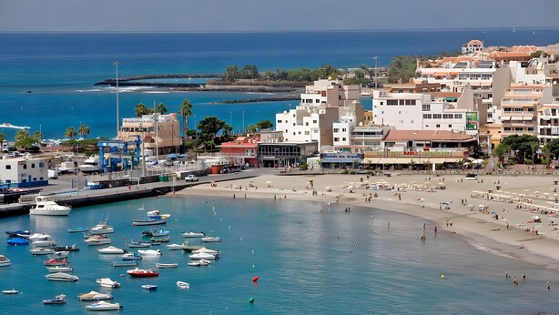 Une ville côtière dotée d’un port de plaisance, d’une plage et de bâtiments.