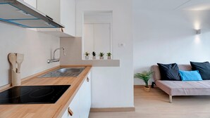 Een moderne keuken met een inbouwfornuis, een spoelbak en een raam met potplanten.