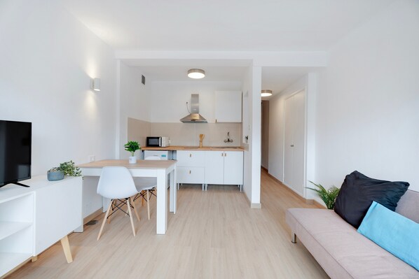 A modern apartment with a kitchen, dining area, and living room.