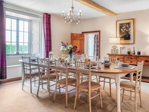 A dining room with a wooden table and chairs, a chandelier, and a view of the outdoors. - 5 bedroom accommodation in Pentney, King&rsquo;s Lynn (Pentney, King&rsquo;s Lynn)