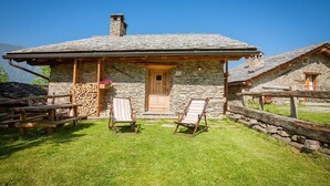 A stone cottage with a wooden door, two lounge chairs, and a stone wall. - Chalet 'Civico 1 ' with Mountain View, Private Garden and Wi-Fi (Marmora)