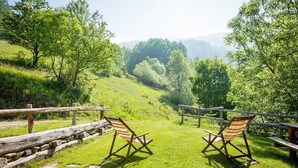 A grassy outdoor area with two wooden chairs and a wooden fence. - Chalet 'Civico 1 ' with Mountain View, Private Garden and Wi-Fi (Marmora)