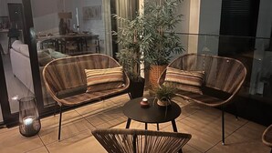 A balcony with wicker chairs, a small table, and a potted plant. - Apartment 'Holiday Apartment Middle Views' with Sea View, Wi-Fi and Air Conditioning (FUENGIROLA)
