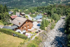 Eine Lodge mit Holzfassade, einer Terrasse und einem Fluss in der Nähe.