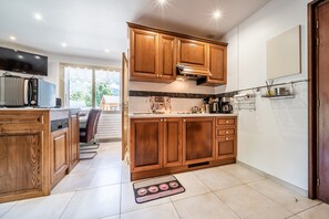 Une cuisine moderne avec des meubles en bois, un four encastré et une grande fenêtre.
