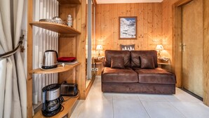 A cozy room with a wooden interior, a sofa, a coffee maker, and a framed picture on the wall. - Studio 'Au Rêve Savoyard 1' with Shared Terrace, for 2 People (Morillon)