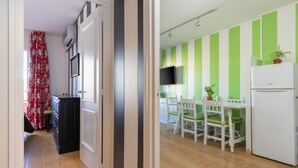 A kitchen with a dining area, a refrigerator, and a television. - Apartment 'Salines' with Shared Pool, Balcony and Air Conditioning (Estartit)