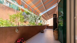 A covered outdoor area with a tiled floor, a green door, and potted plants. - Holiday Apartment 'Paradiso Marino' with Terrace, Garden and Wi-Fi (Cefalù)