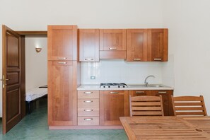 A compact kitchen with wooden cabinets, a gas stove, and a sink.