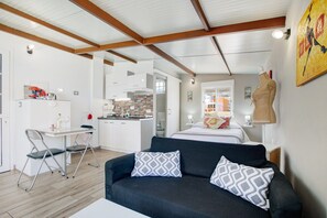 A modern interior with a sofa, a dining table, and a kitchenette.