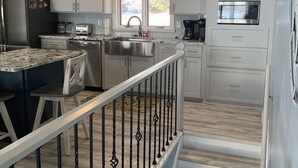 A modern kitchen with white cabinets, a granite countertop, a stainless steel sink, a microwave, and a refrigerator. - Lakefront,  Great, wide-water views. Near bridge
 (Moneta)