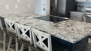 A modern kitchen with a central island, bar stools, stainless steel appliances, and a white door. - Lakefront,  Great, wide-water views. Near bridge
 (Moneta)