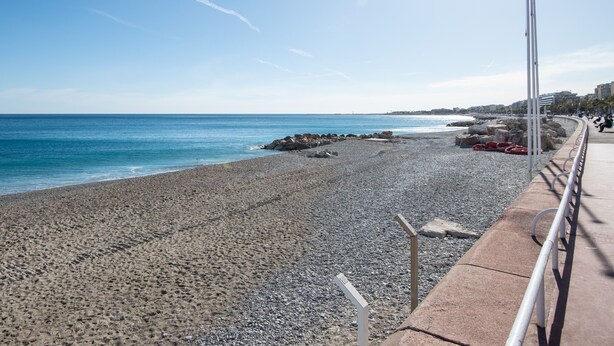 A pebble beach with a metal railing and a clear blue sky. - Modern Apartment - Promenade des Anglais in Nice (Nice)