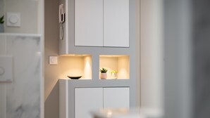 A modern kitchen with white cabinetry, recessed lighting, and a small plant on the countertop. - Modern Apartment - Promenade des Anglais in Nice (Nice)