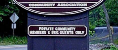 A sign for Big Bass Lake Community Association, indicating it is a private community for members and registered guests only.