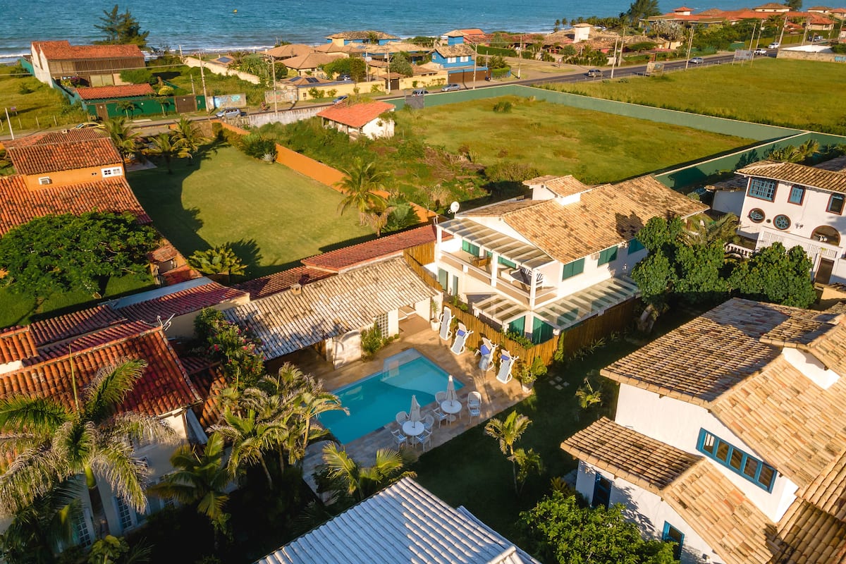 Un quartier résidentiel situé sur la côte, avec des maisons, une piscine et une vue sur la mer.