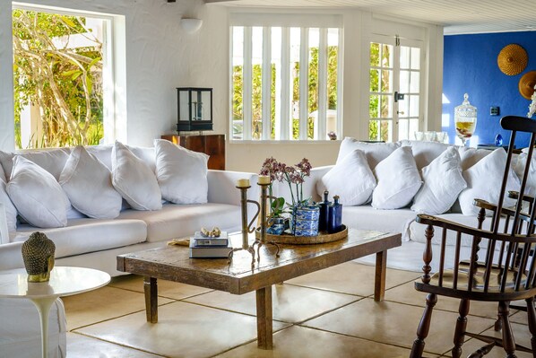 A living room with a white sofa, a wooden coffee table, and a wooden chair.