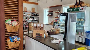 Eine Theke in einer Bäckerei mit Körben voller Snacks, einem gekühlten Ausstellungsregal und einer Holzbalkendecke.