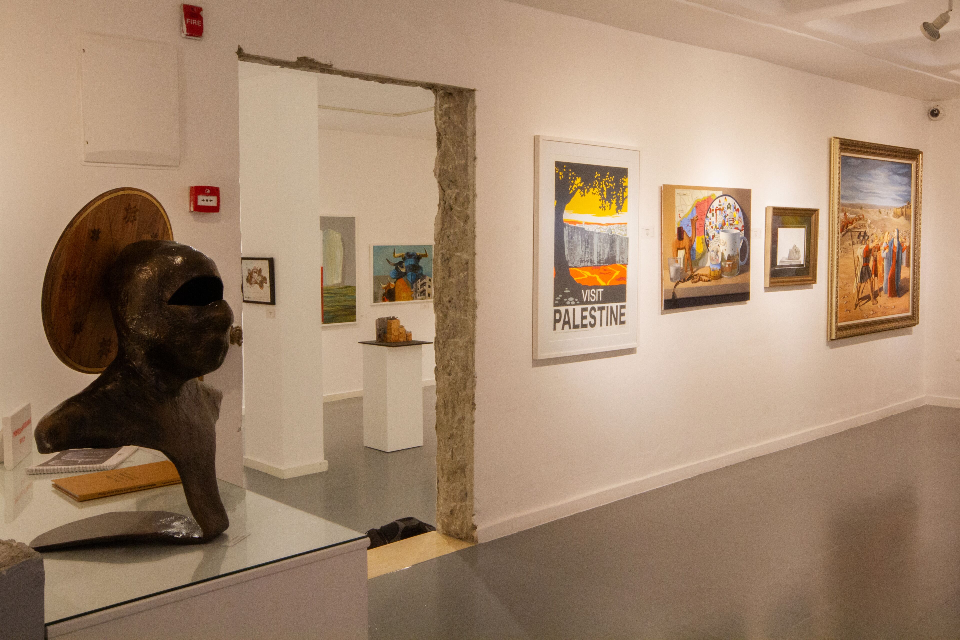 An art gallery with various artworks on display, including a sculpture and framed paintings.