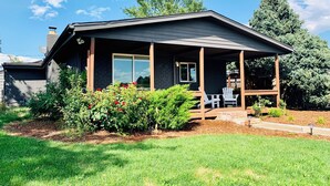A modern house with a covered porch, a brick exterior, and a well-maintained garden.