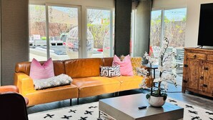 A modern living room with a leather sofa, a coffee table, and a TV stand.