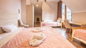 Habitación de hotel con dos camas, un escritorio y una silla.