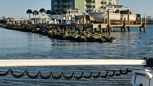 Un hotel frente al agua con varios balcones, un muelle y barcos.