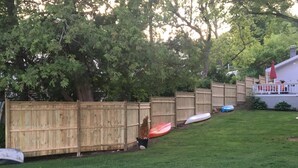 A wooden fence with kayaks lined up behind it. - Lake Front Chalet (Queensbury)