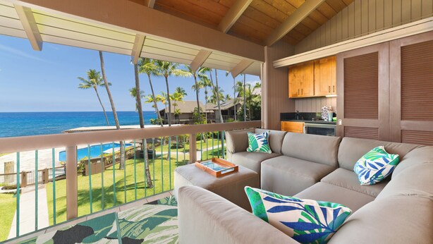 A balcony with a view of the ocean, a sofa with cushions, and a small table with a tray. - High-End Oceanfront Sanctuary with Upgraded Luxury Interior (Kailua Kona)