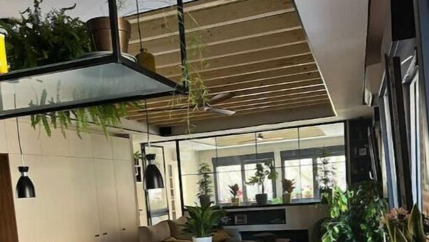Een moderne keuken met een houten kookeiland, een spoelbak en een eethoek met stoelen en een tafel.