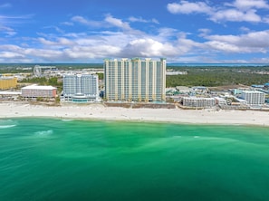 Un hotel costero con varios edificios altos, una playa y cielo despejado.
