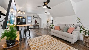 Un appartement moderne de style « loft » comprenant un coin repas, une cuisine et un salon.