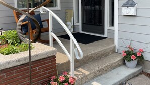 Una casa con escalera de caracol, felpudo y plantas en macetas.