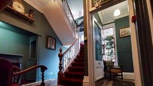 Un escalier dont les marches sont décorées d’un motif particulier, menant à une pièce d’où l’on peut admirer un jardin.