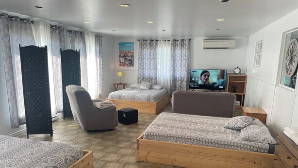 Una habitación de hotel moderna con una cama grande, un sofá, una silla y un televisor.