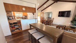 A kitchen with wooden cabinets, a built-in oven, and a dining area with a wooden table and chairs. - Good Vibes getaway lake views, Marina, private Boat Slip (Bass Lake)