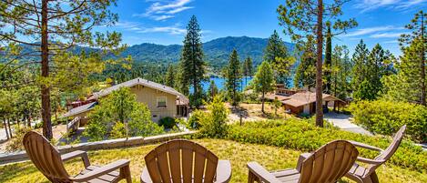 Zona residencial con varias casas, vista despejada de un lago y montañas al fondo.