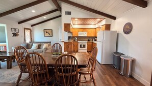 A spacious kitchen with wooden cabinets, a central island, and a dining area with wooden chairs. - Good Vibes getaway lake views, Marina, private Boat Slip (Bass Lake)