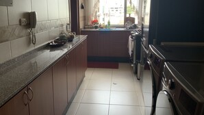 A kitchen with a built-in oven, a sink, and a telephone. - Serenity Inn (Quito)
