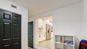 Et moderne køkken med hvide skabe og et rustfrit stål køleskab.