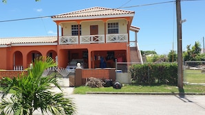 A two-story house with a balcony, a garage, and a small garden area.