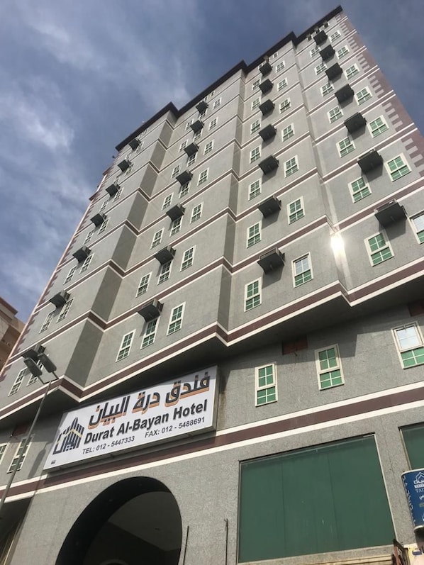 Un hotel de varios pisos con un letrero que indica que es el Hotel Durat Al-Bayan.