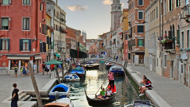 Un canal dans une ville historique, bordé de rues étroites et d’immeubles des deux côtés.